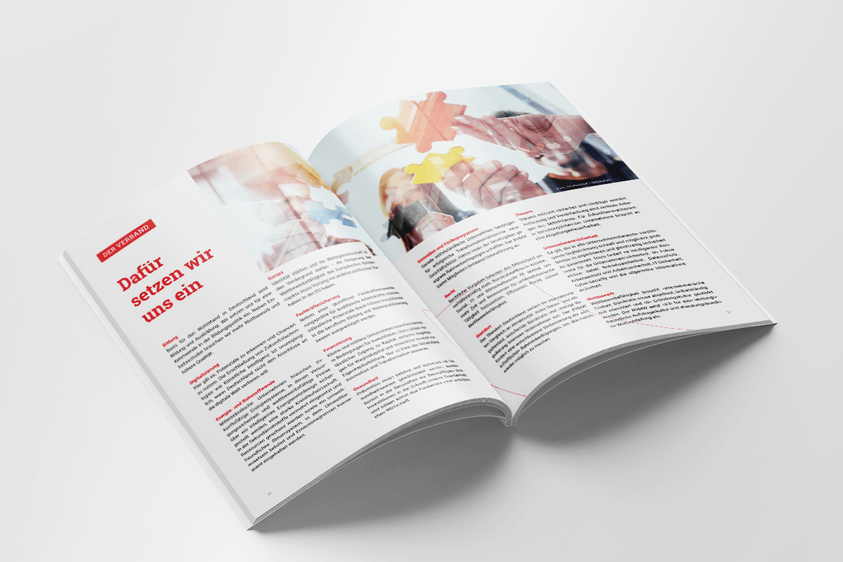 Aufgeschlagenes Magazin in deutscher Sprache mit Text, roten Überschriften und verschwommenen Händen, die auf den oberen Seiten Puzzleteile zusammensetzen.